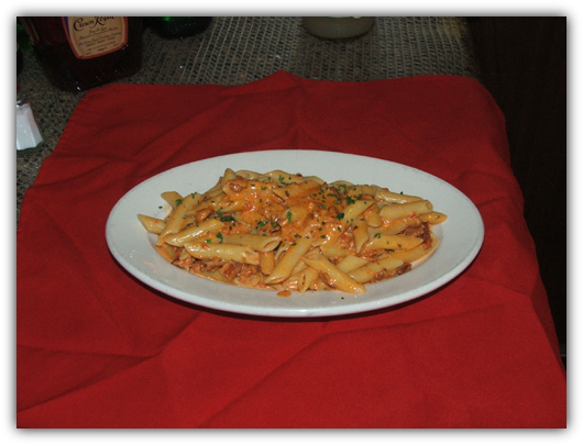 Penne Alla Vodka with flamed vodka in a pink sauce with bacon.